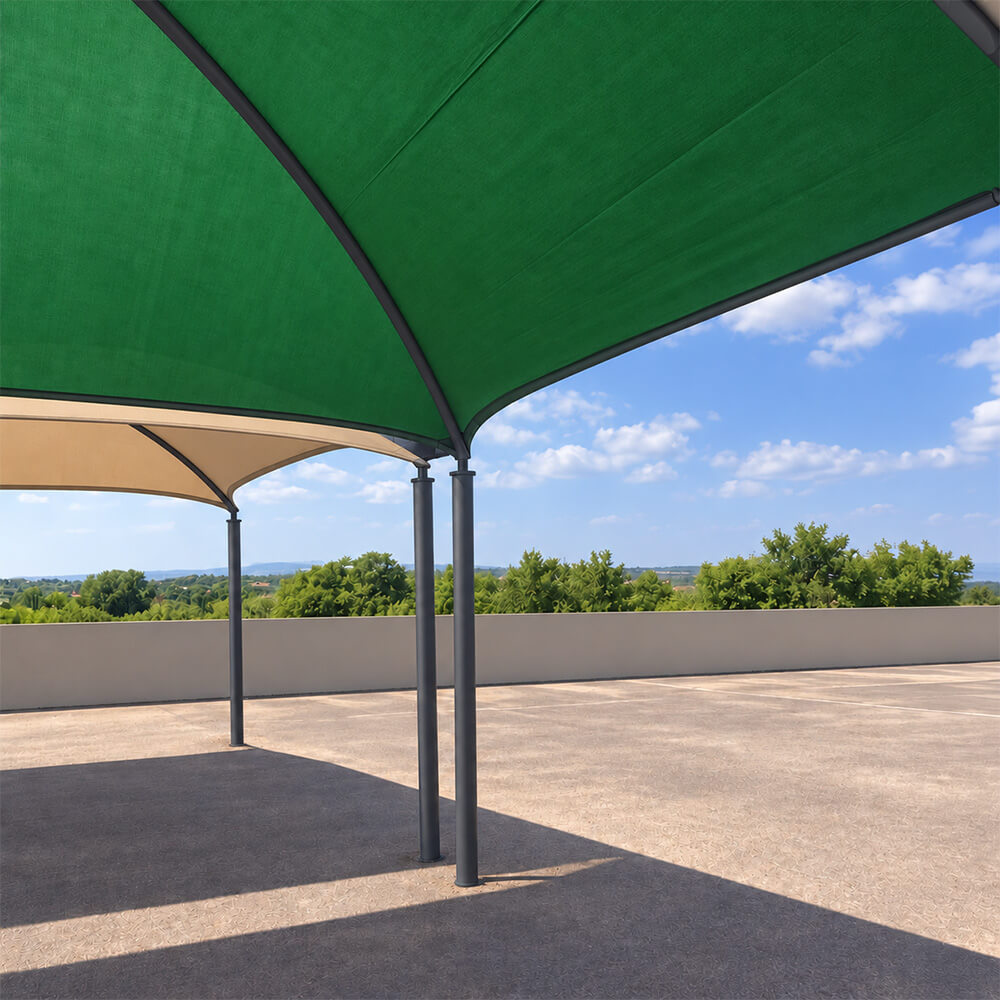 Low-angle view of a polished charcoal 4-post shadeport frame supporting forest green shade netting.